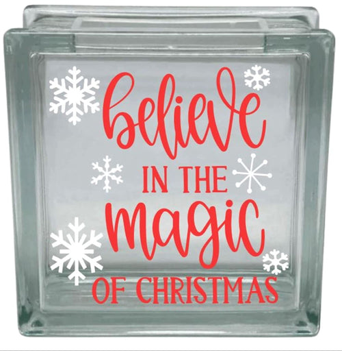 Glass block with 'believe in the magic of Christmas' text and snowflakes on a white background